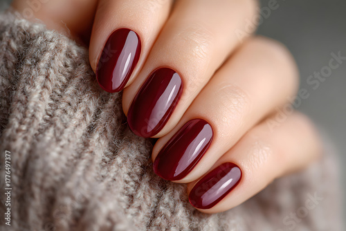 Professional female hand model displaying perfect nail manicure featuring deep burgundy polish and French manicure design showcasing beauty salon treatment luxury cosmetics and elegant nail care.