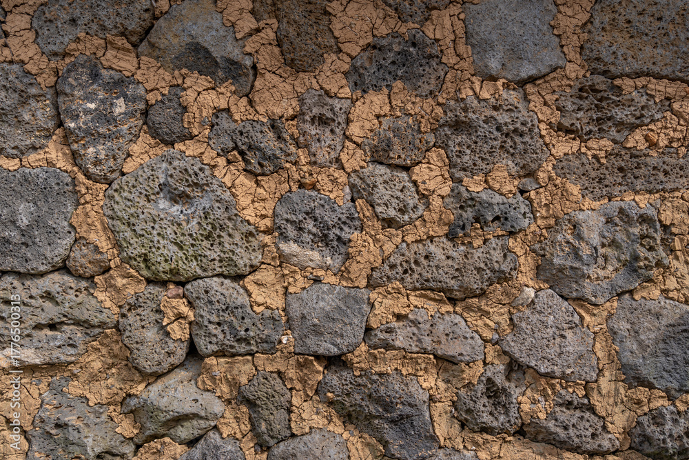 Naklejka premium A timeworn stone wall, where lava meets earth