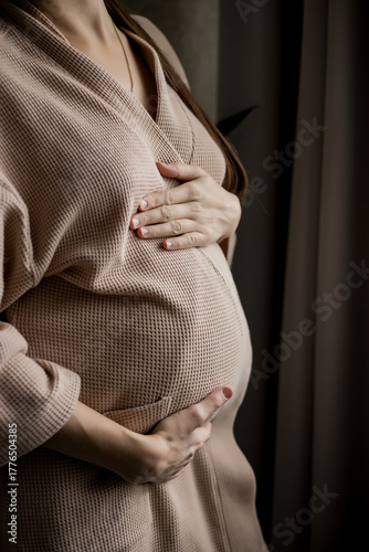 pregnant female with arms on her round belly