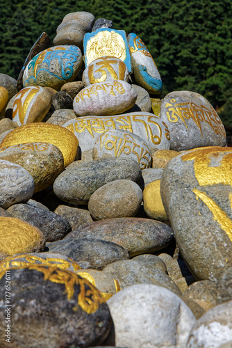 Painted stones with buddhist mantras in Kurjey monastery gardens