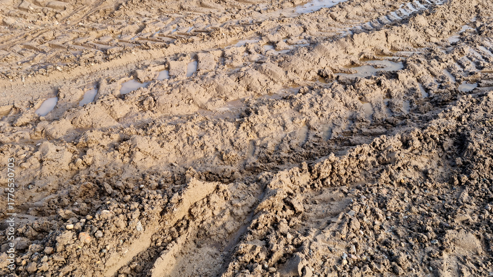 Fototapeta premium Wheel tracks in the mud. Ruts and puddles. Close-up.