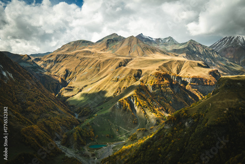 Wallpaper Mural Majestic autumn landscape of the Caucasus mountains in Georgia with golden slopes and a small turquoise lake in the valley. Dramatic light and vibrant colors of untouched nature Torontodigital.ca