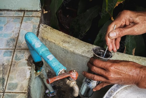 Papier peint Clogged sink pipe in hands ,A plumber cleans a clogged siphon pipe of a sink in the kitchen