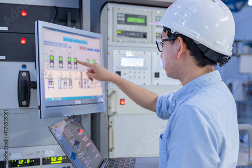 Electrical engineer male checking voltage at the Power Distribution Cabinet in the control room,preventive maintenance Yearly,inspecting power system and control panel in industrial factory