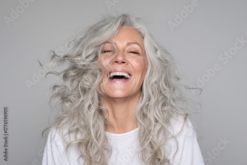 Happy Senior Woman with Gray Hair Smiling Joyfully in White Shirt.