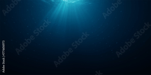 Bright sunlight rays burst through the deep blue ocean water in a seamless underwater world loop with a faint glow, resembling a blue sky
