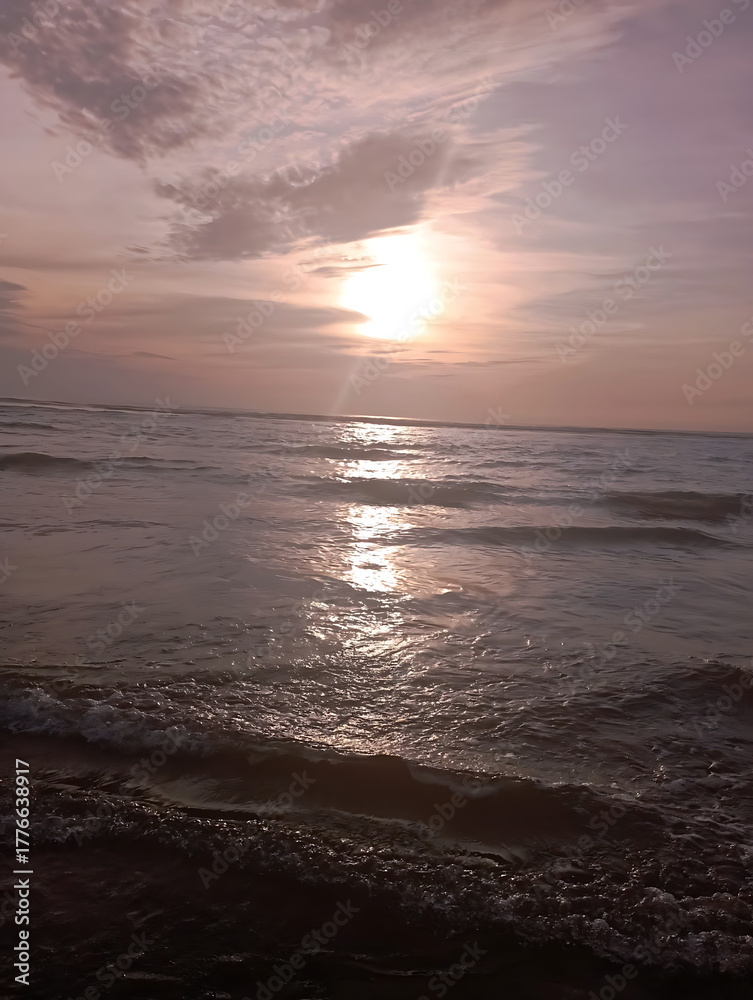 Obraz premium Sunset over the ocean with waves and colorful sky