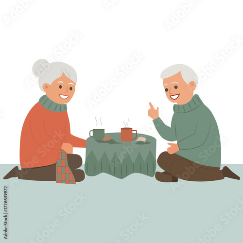  An elderly man and woman sit on the floor at a low table