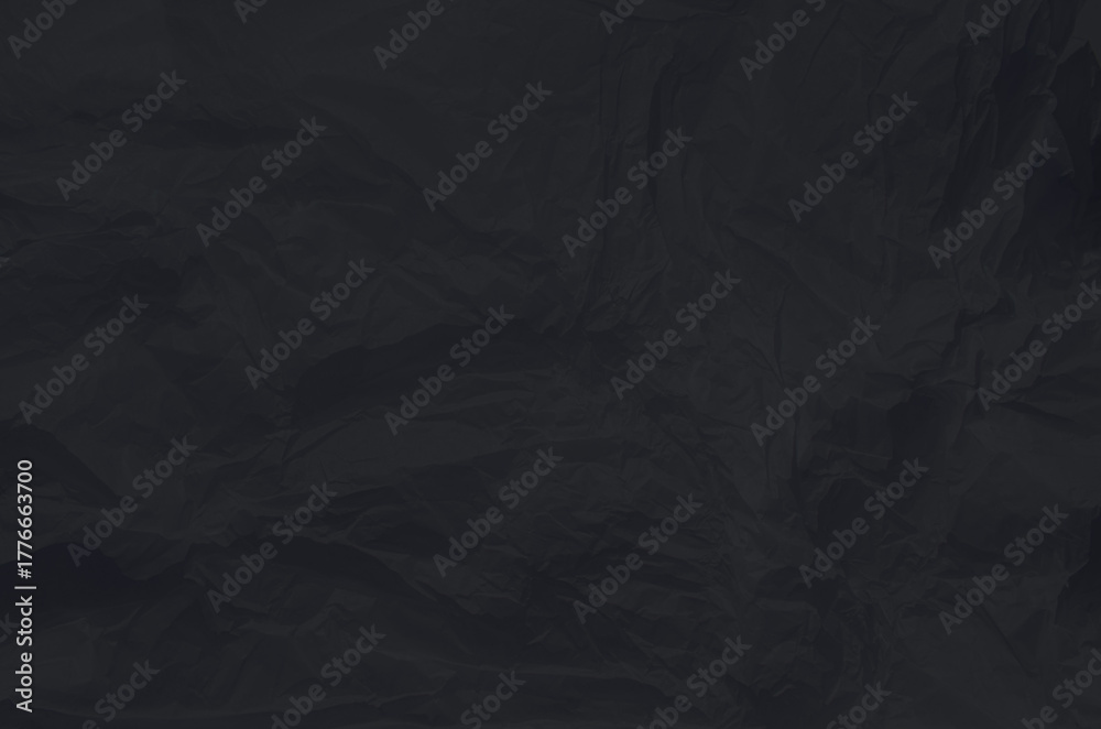 Fototapeta premium A close-up view of crumpled wrinkled black paper Unique texture and depth creating interesting shadows and highlights. Copy space for your design or text.