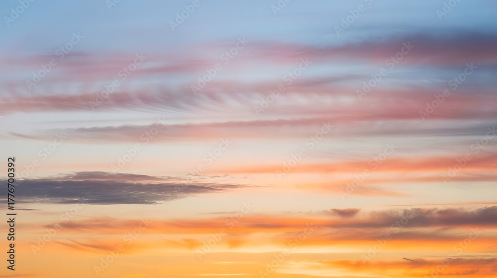 Fototapeta premium Sunset Sky With Wispy Pink and Orange Clouds Across a Blue Sky stock photo