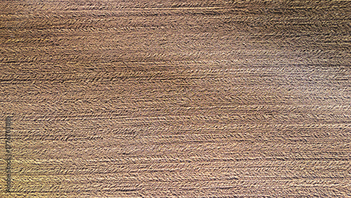 Close-up view of textured earth surface with distinct patterns created by farming equipment, showcasing the rich brown soil in an agricultural field.