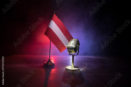 Microphone on a background of a blurry flag of Austria close-up. dark table decoration