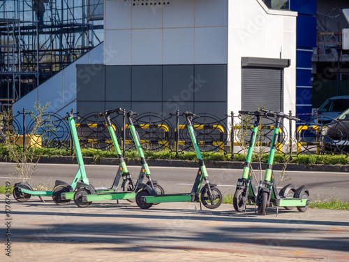 Electric scooters parked on city street. Urban mobility, eco-friendly transportation, sharing economy and sustainable commuting.