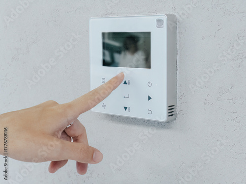 Human finger press control panel of the air conditioner on the wall