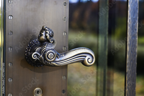 an ornate bronze door handle shaped like a cherub or angel figure