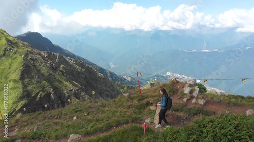 Two tourists walk along a trail on a mountain ridge, drone video, mountain walk, stunning nature