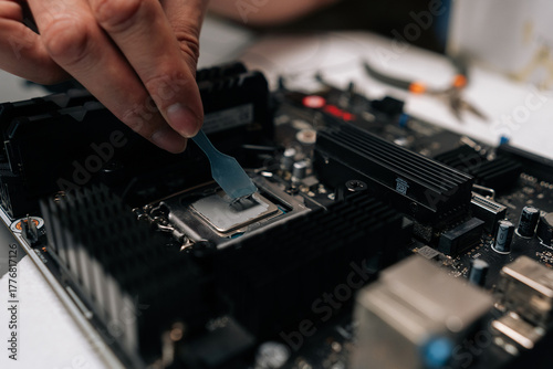 Tableau sur toile Professional technician applying thermal paste to CPU of computer motherboard, ensuring optimal heat dissipation during maintenance or upgrade service in workshop