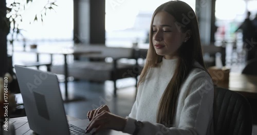 Woman freelancer working by laptop PC sitting in cafe