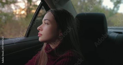 Relaxed woman passenger looking out the car window sitting with comfort
