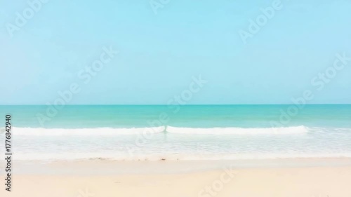 A tranquil coastal panorama featuring an azure sky, gentle waves, and a pristine beach, evoking a sense of calm and natural beauty.