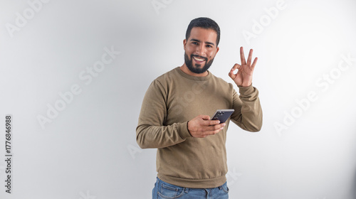Man Giving OK Sign While Holding Smartphone