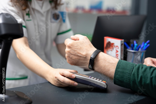 Fotografi Close up of senior man pays with smart watch at the POS in a pharmacy shop, purchasing medication and self care items in a modern high tech healthcare environment