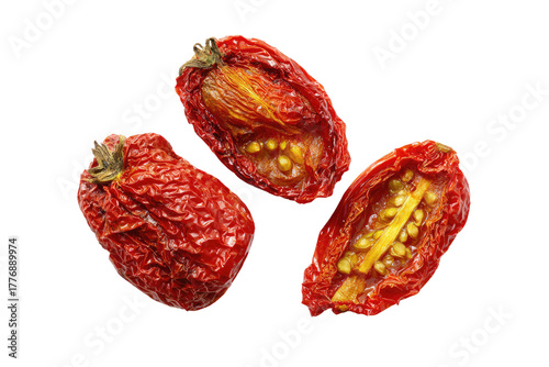 Three sun-dried tomatoes, halved, show wrinkled, deep red skins and visible, golden seeds within