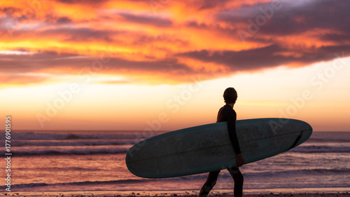 Foto Surfer hitting the waves during sunset