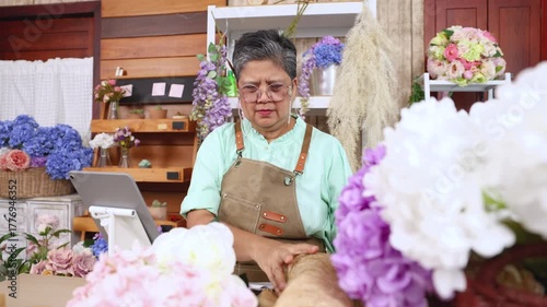 Asian senior woman, florist, small business owner, entrepreneur arranges flowers with passion at shop, showing creative occupation, independent lifestyle, customer service, retirement, aging society
