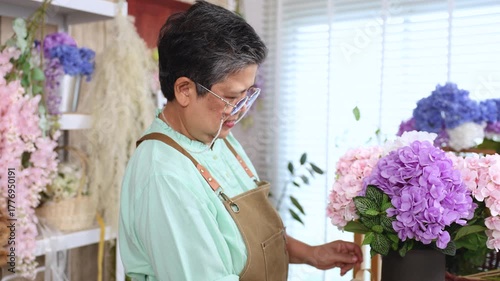 Asian senior woman, florist, small business owner, entrepreneur arranges flowers with passion at shop, showing creative occupation, independent lifestyle, customer service, retirement, aging society