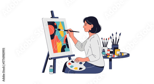 Artist paints abstract art at easel brush in hand palette paints  brushes nearby