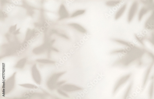 Delicate plant and leaf shadows cast on a smooth beige wall surface. Minimalist natural background ideal for eco design, interior decor, wellness, spa, and organic product mockups or branding.
