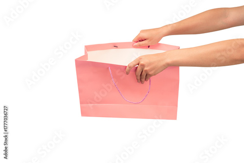 Hand holding pink shopping bag isolated on transparent background