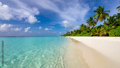 Fototapeta Naklejka Na Ścianę i Meble -  Stunning view of a white sand beach with crystal clear turquoise water. Lush palm trees line the tropical coast under a sunny, blue sky.