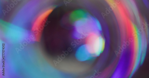 Iridescent blur glow. Whirl futuristic flare. Red purple blue light mixing color on black background. Neon reflection abstract luminosity.