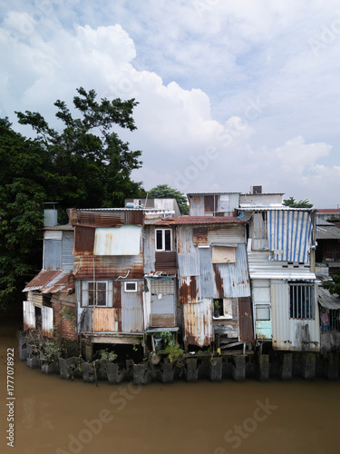 old shanty style houses on Southeast asian canal in Ho Chi Minh City made from odd sheets of corrugated iron. 