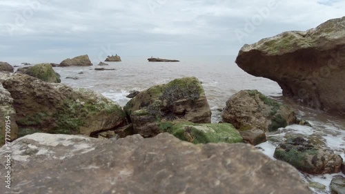 Atlantic waves crash over rocks on beach near Sidmouth in South Devon England with audio