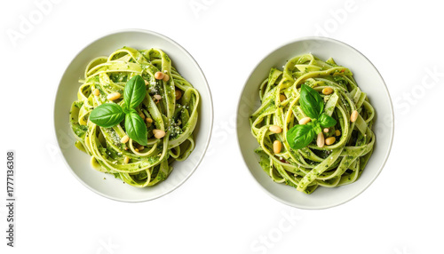 Two bowls of pesto pasta, garnished with pine nuts & basil