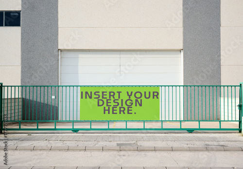 A green gate stands in front of a building with a blank space for design