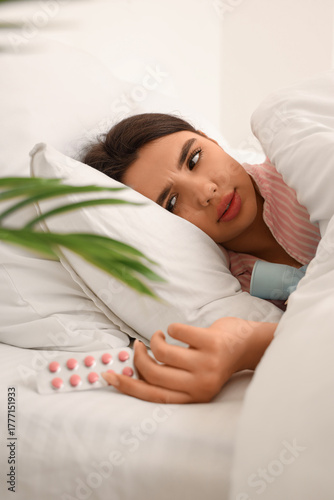 Sick young woman with pills...