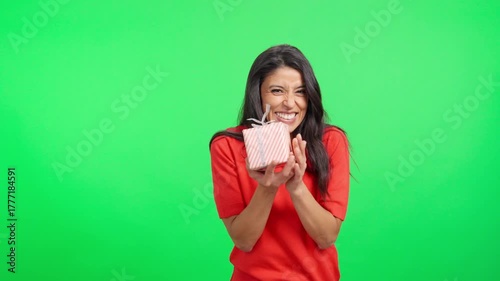Happy woman giving a gift box on green screen background