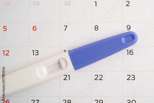 Pregnancy test and birth control pills on calendar, contraception health and medicine.