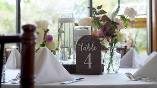 Slow-zoom out from table 4 at a wedding reception. Wedding day details and decor.