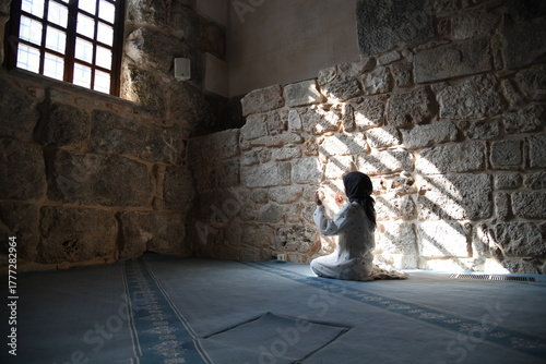 Stille Einkehr: Frau in einem antiken Gebäude, sitzend im Sonnenfleck
