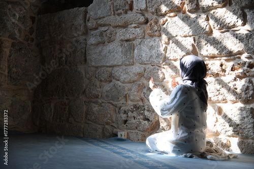 Stille Einkehr: Frau in einem antiken Gebäude, sitzend im Sonnenfleck