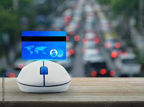 Fototapeta Naklejka Na Ścianę i Meble -  Credit card on wireless computer mouse on wooden table over blur of rush hour with cars and road, Online e-payment concept, Elements of this image furnished by NASA