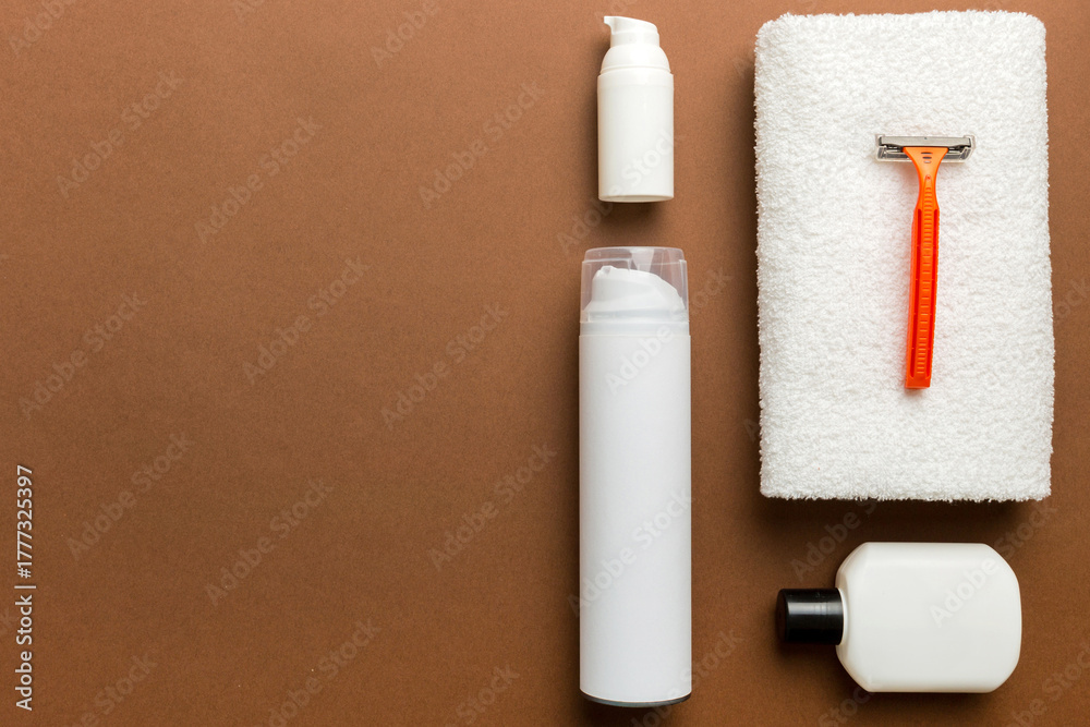 Naklejka premium shaving man set. shaving machine, towel, lotion and shaving foam on colored background. Men bath Accessories top view