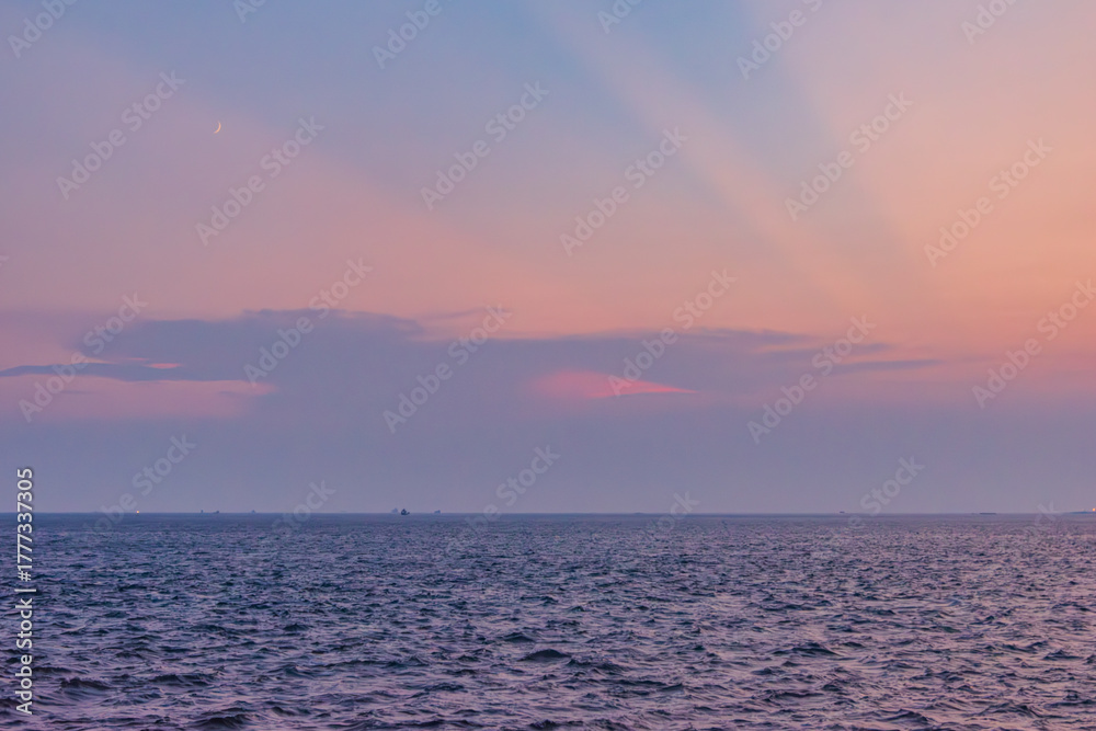 Obraz premium 光放つ夕空と海