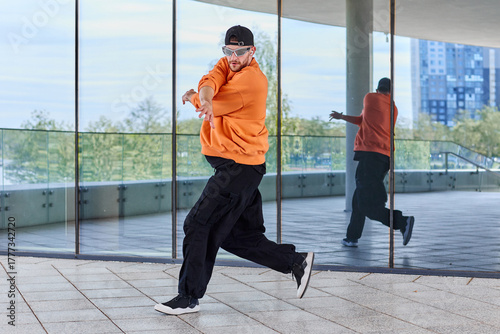 Stylish hipster man in cool clothes dances electro choreography