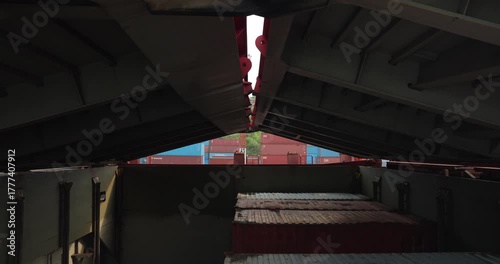 Safe metal hatch covers cargo containers in bulk carrier hull in marine port. Heavy tanker transports goods and packages by sea ways